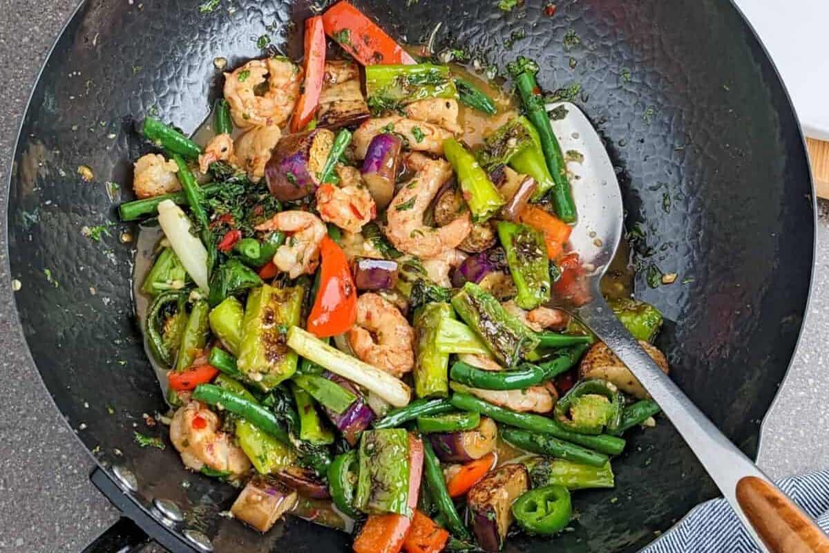 Vibrant shrimp stir-fry with colorful vegetables in a black wok, ready to serve.