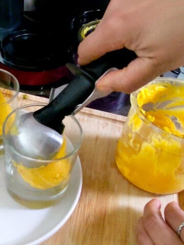 gelato being scooped into glass cups.