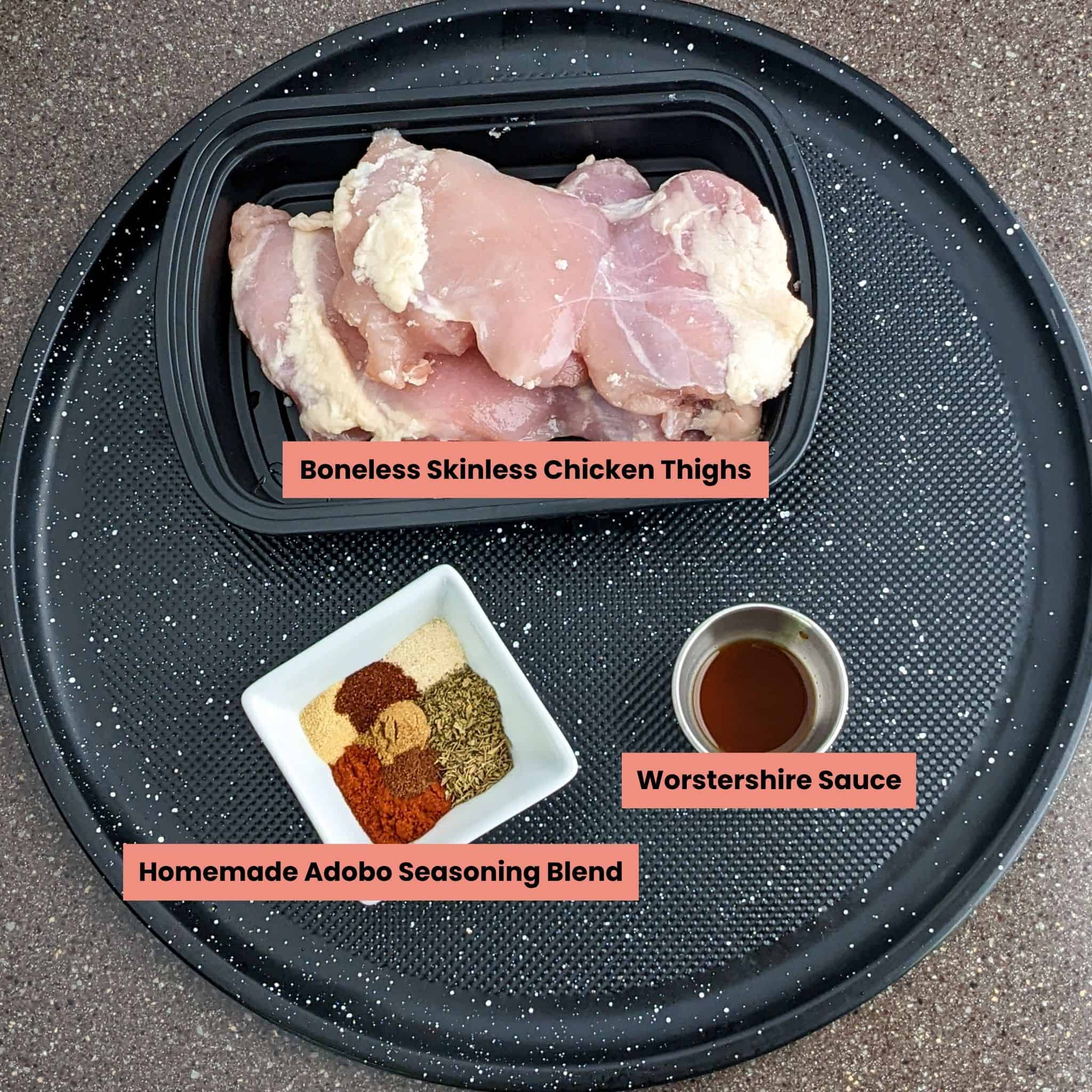boneless skinless chicken thighs, adobo seasoning and worstershire ingredients on a round tray.