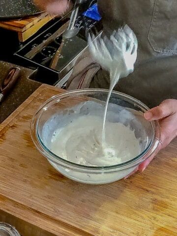 mixing dressing using a whisk and bowl.