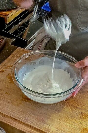 mixing dressing using a whisk and bowl.