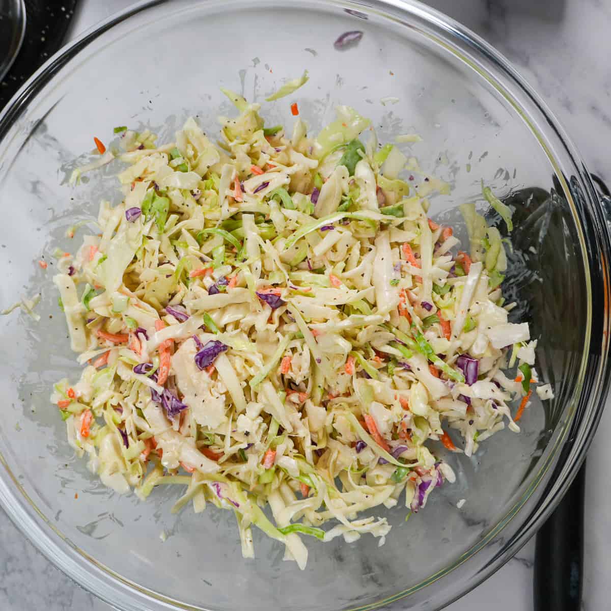 completed homemade coleslaw in a mixing bowl.