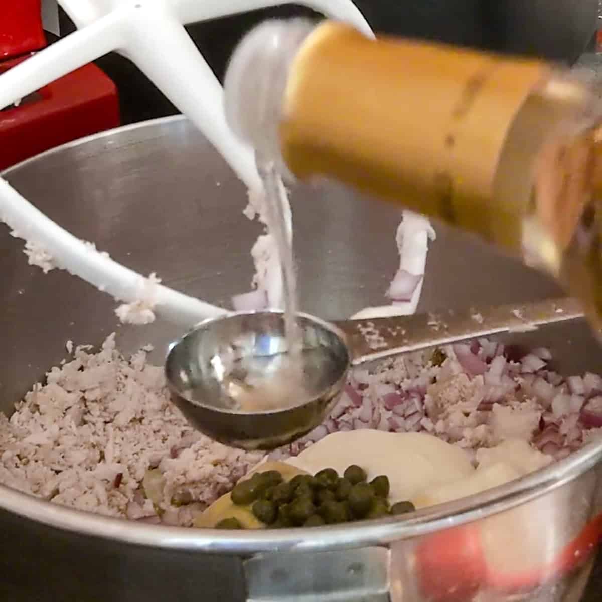 pouring a measure of white wine vinegar.