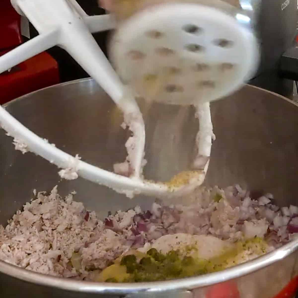 shaking all purpose seasoning into the stand mixing bowl.
