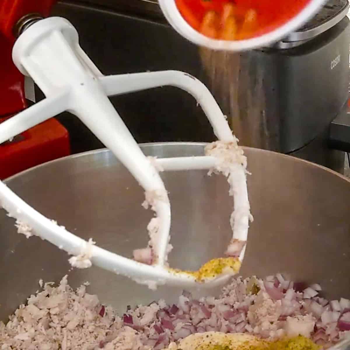 shaking in slay ya mama cajun sesoning into mixing bowl.