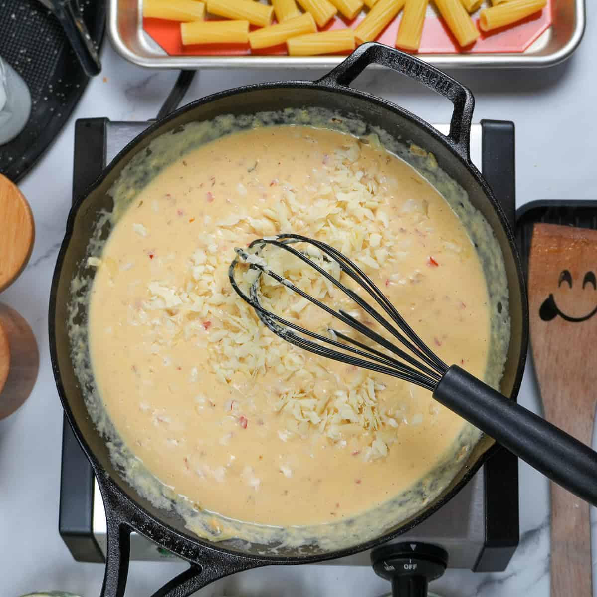 creamy cheese base for the haitian style shrimp white macaroni and cheese in a cast iron skillet.