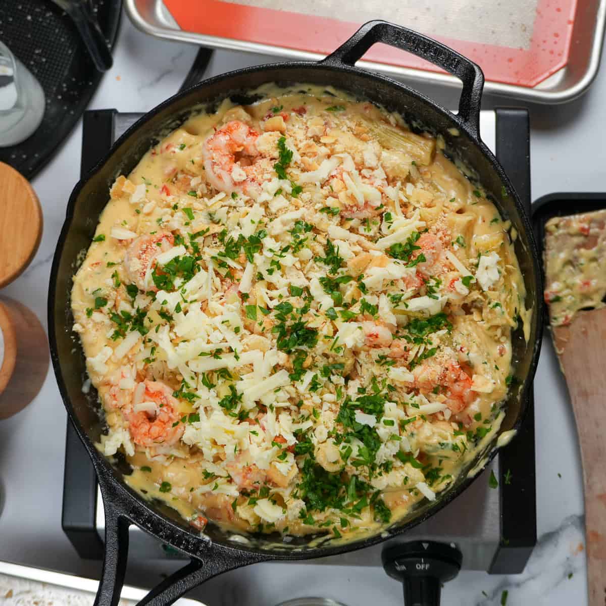 shrimp mac and cheese topped with crumbled ritz crackers, shredded cheeses, argentinian red shrimp and chopped parsley.