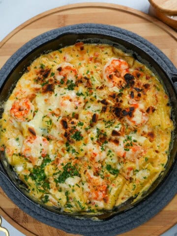 Broiled haitian style shrimp mac and cheese in a lodge cast iron blackock skillet.