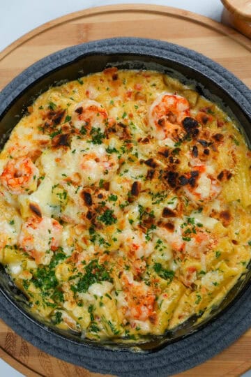 Broiled haitian style shrimp mac and cheese in a lodge cast iron blackock skillet.