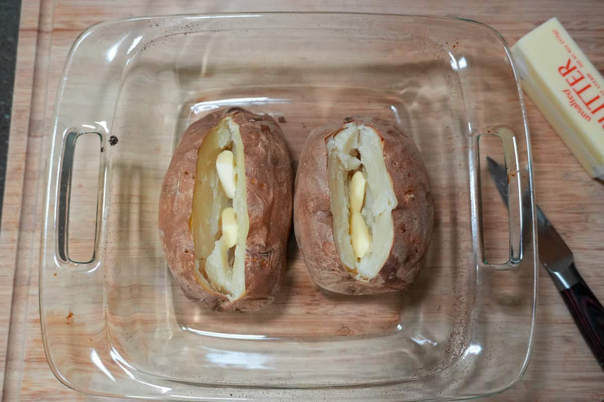 baked potatoes with sliced butter inside.
