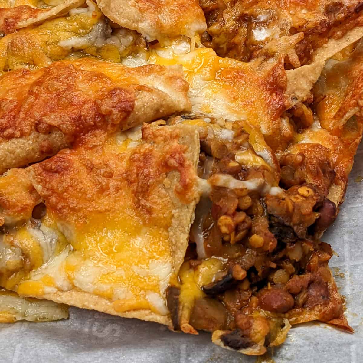 close up of the Protein-Packed Vegetarian Nachos Recipe on parchment paper.