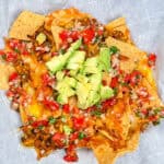 top view of the Protein-Packed Loaded Vegetarian Nachos topped with pico de gallo and fresh avocado chunks.