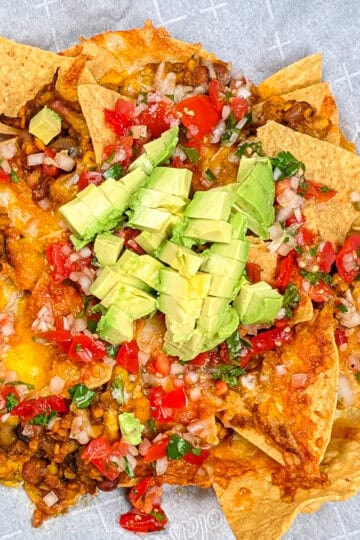 top view of the Protein-Packed Loaded Vegetarian Nachos topped with pico de gallo and fresh avocado chunks.