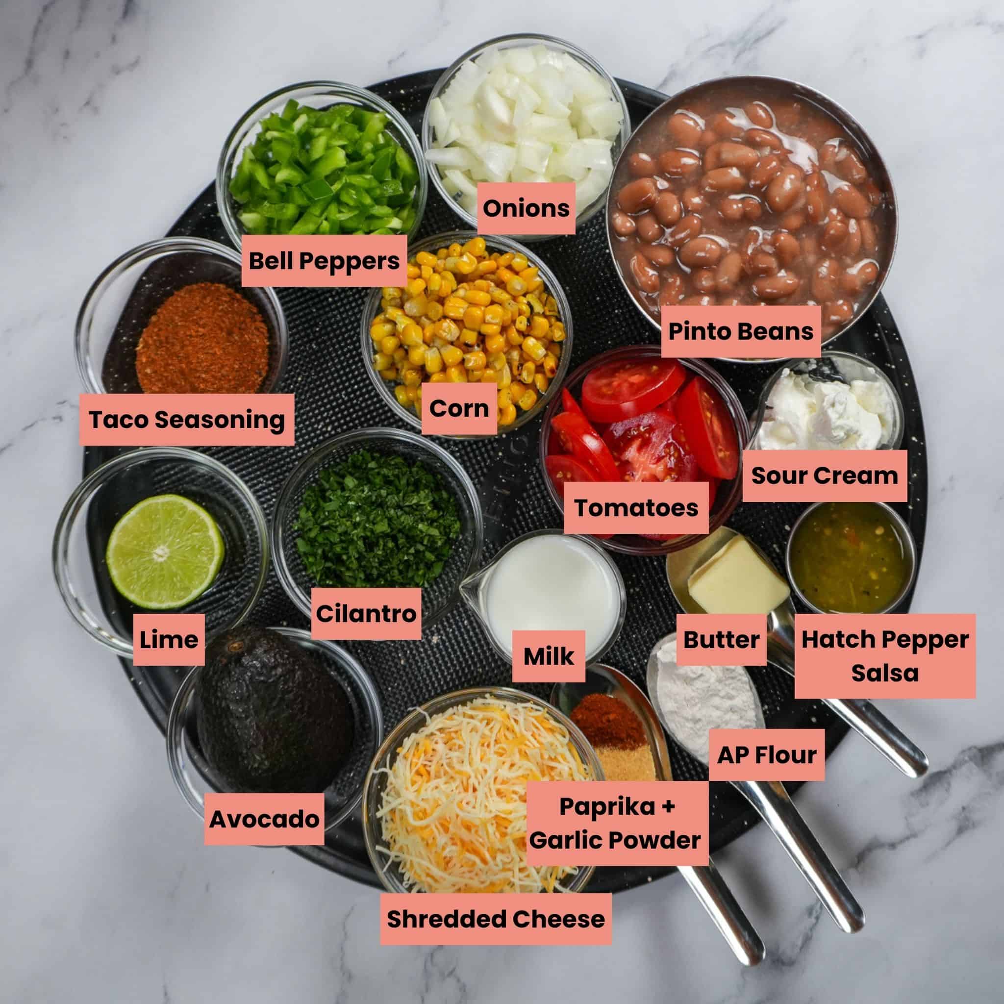 ingredients for the ultimate loaded nachos on a round tray in containers and labeled.