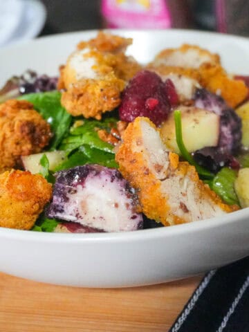 close up of the Fresh Berry Apple Pecan Chicken Salad with Goat Cheese in a wide rim bowl.