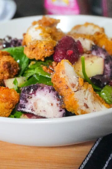 close up of the Fresh Berry Apple Pecan Chicken Salad with Goat Cheese in a wide rim bowl.
