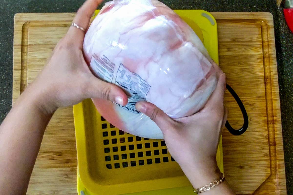 draining the excess liquid from the whole chicken.