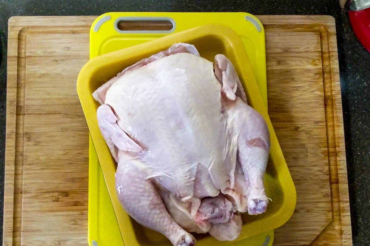 plastic packaged removed from the chicken and is laying in the drainage tray.