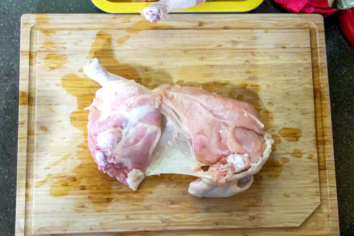 chicken half skin down on the cutting board.