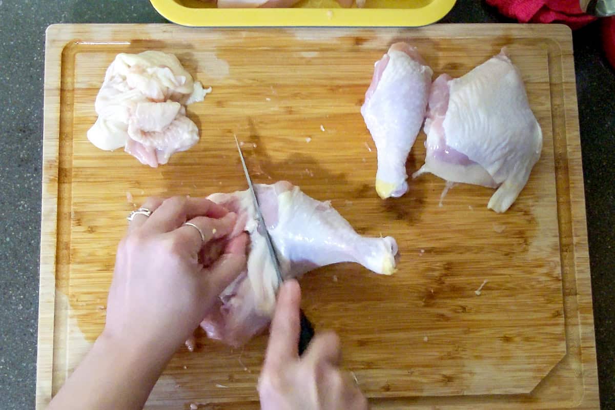using the the knife to separate chicken thigh from drumstick aka leg.