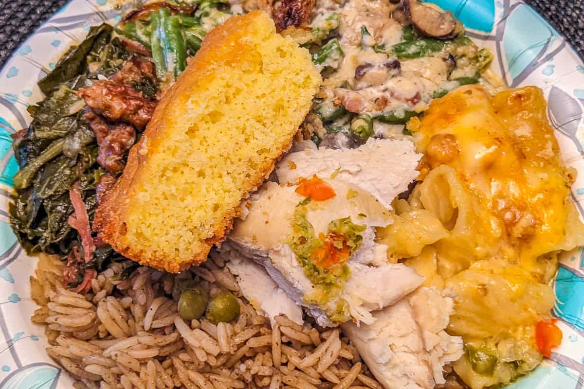 Haitian American Thanksgiving plate with diri djon djon, cornbread, collard greens, haitian mac and cheese and green bean casserole.