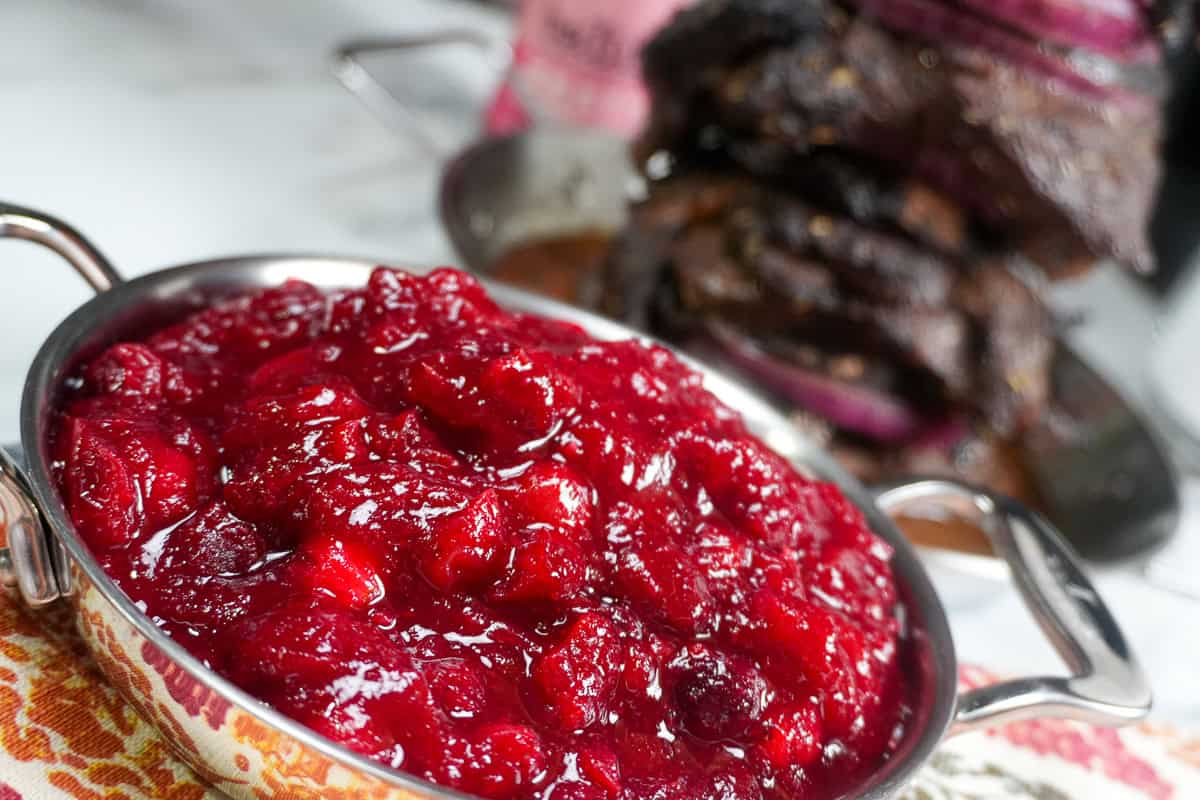 close up of the Fresh Cranberry Ginger Chutney with beiutui marinaded steak shawarma in the background.
