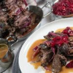 full layout of holiday steak shawarma plated next to a small decorative pot of gravy, beefs shawarma tower and cranberry chutney.