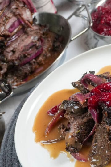 full layout of holiday steak shawarma plated next to a small decorative pot of gravy, beefs shawarma tower and cranberry chutney.