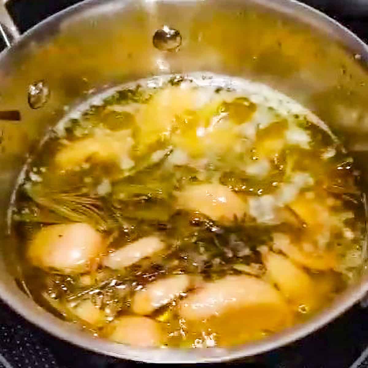 simmer garlic cloves and herbs in olive oil and butter in a small all-clad pan.