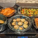 5 prepared dishes on a stove.