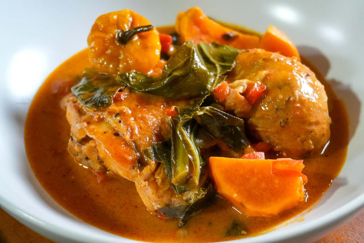 close up of the West African Peanut Stew with Chicken and Collard Greens in a wide rim bowl.