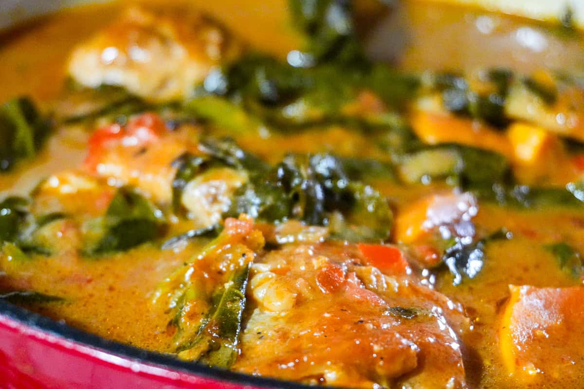 close up of the West African Peanut Stew with Chicken and Collard Greens in a dutch oven.