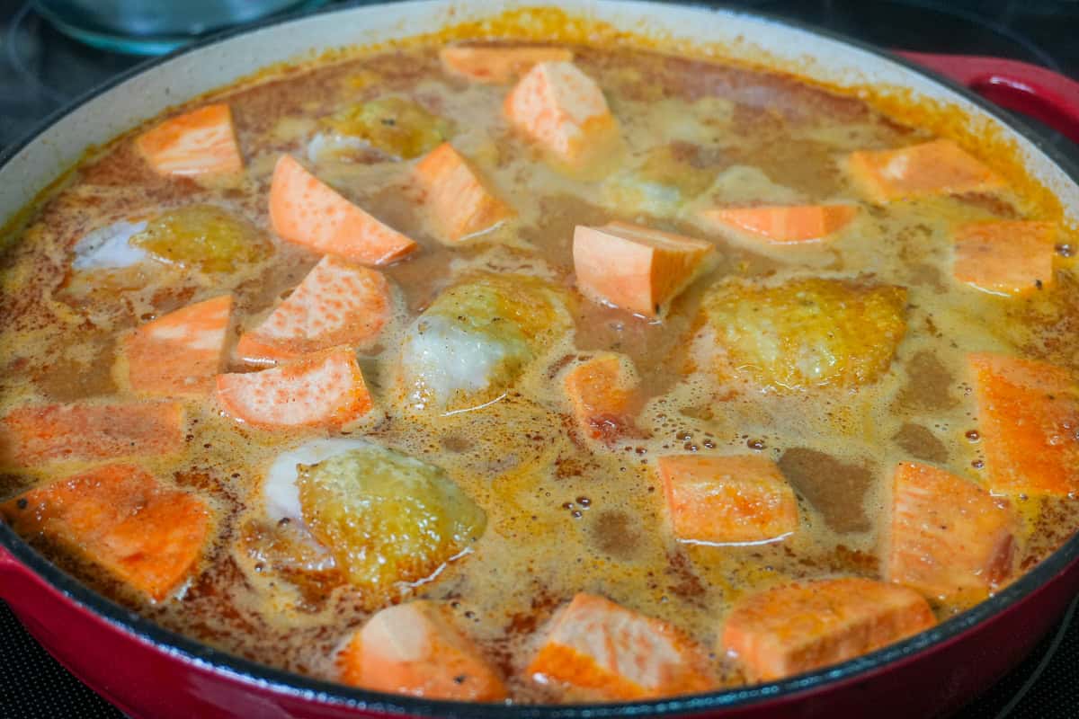 maafe with sweet potatoes and seared chicken in a pot.
