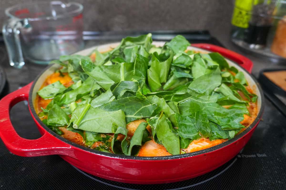 fresh chopped collards added to the dutch oven as the finale to the West African Peanut Stew with Chicken and Collard Greens recipe.