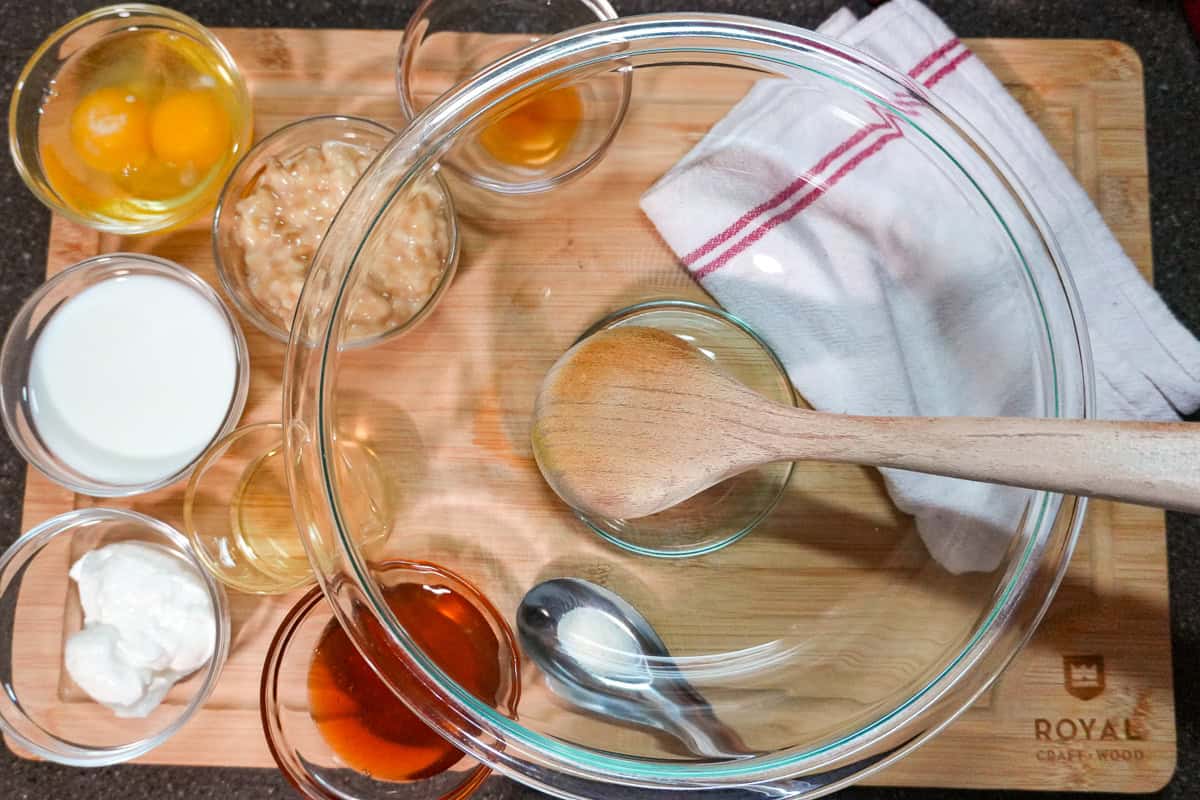 large glass mixing bowl next to smaller glass bowls filled with ingredients.