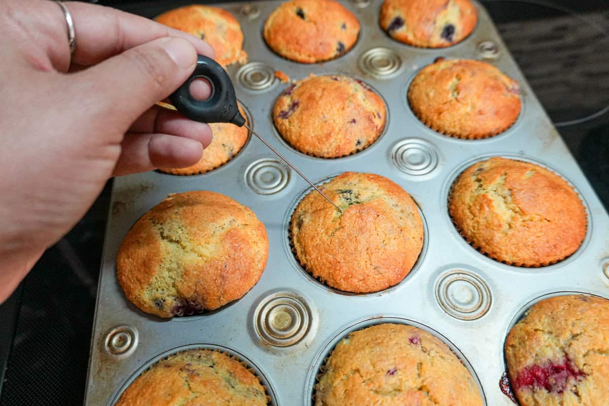 cake tester piercing a baked muffin.