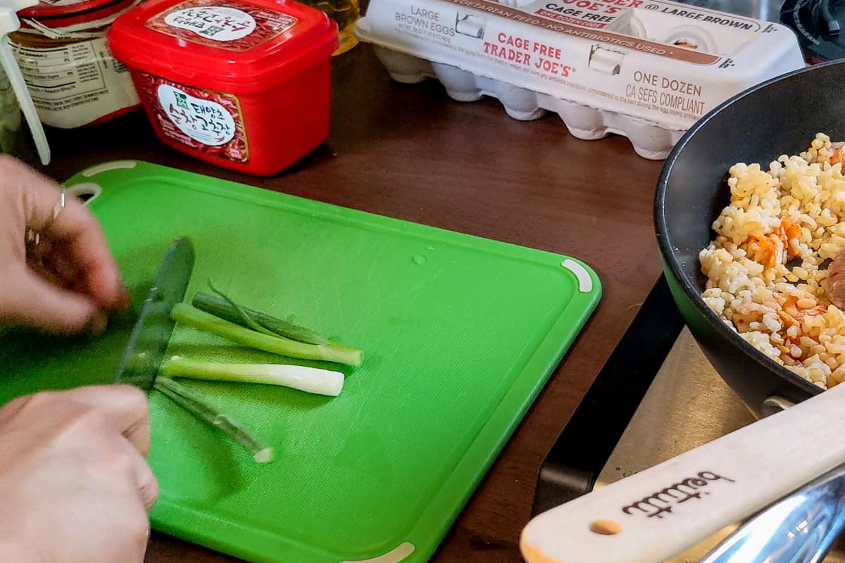 3 inch scallion pieces on a cutting board.