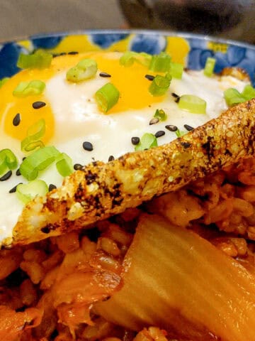close up of garnished fried crispy egg on kimchi rice.