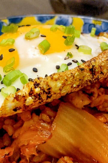 close up of garnished fried crispy egg on kimchi rice.