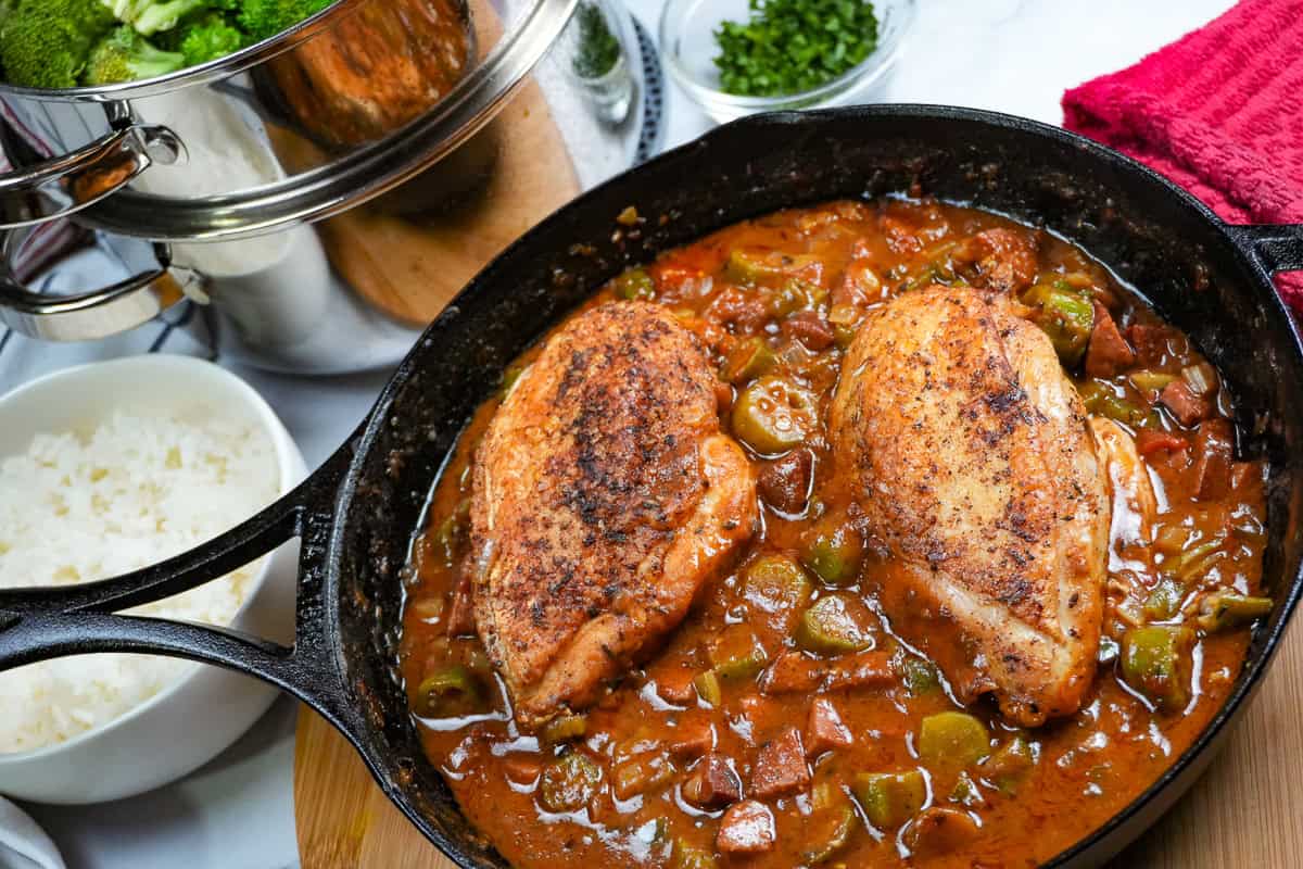 cast iron skillet of the Pan-Roasted Chicken and Andouille Sausage Gumbo surrounded by other ingredients..