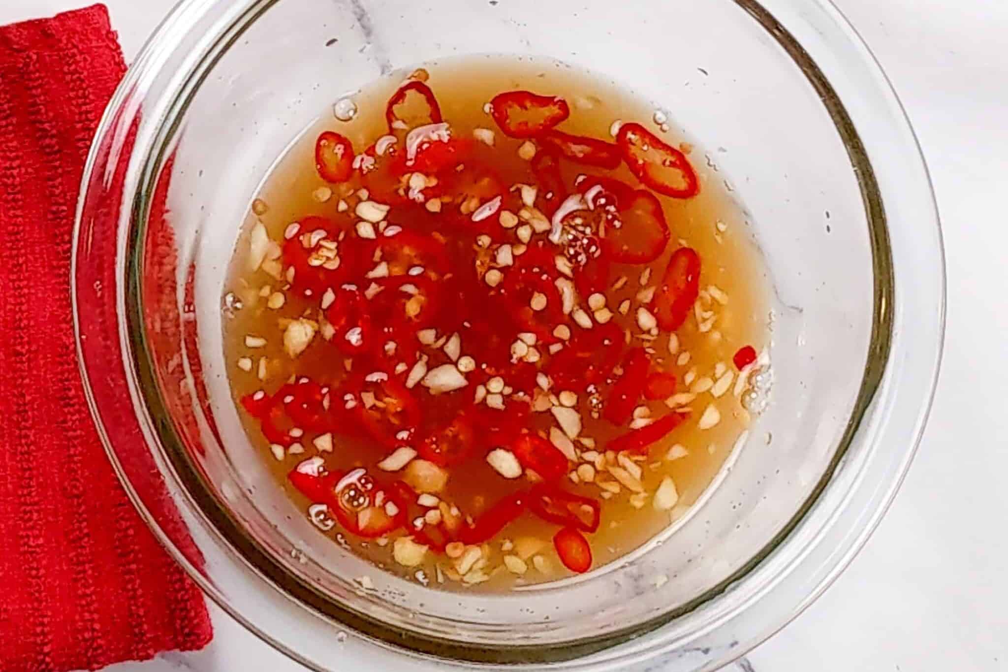 nouc cham sauce in a glass container.