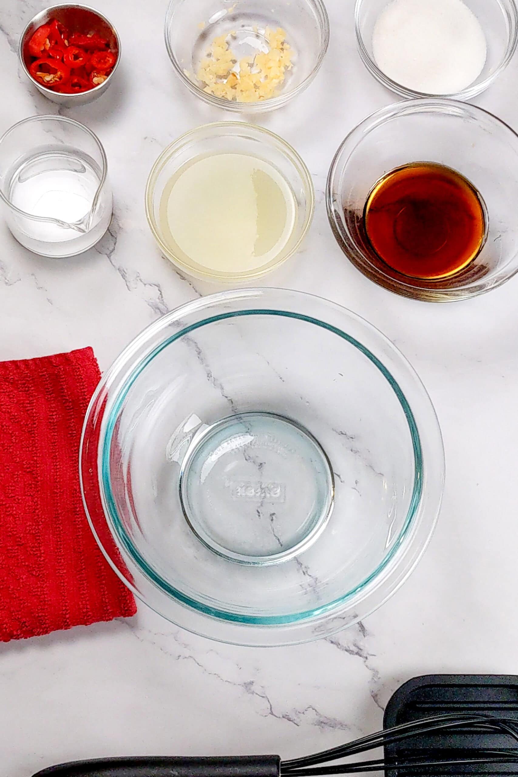 Ingredients for the Nuoc Cham Sauce next to a glass mixing bowl and whisk.