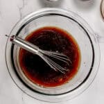 the finished Spicy Sesame Soy Dressing in a glass bowl with a mini whisk