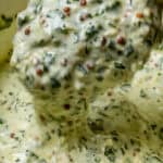 close up of the Lemon Dijon Mustard Remoulade on a spoon dripping back into a container.