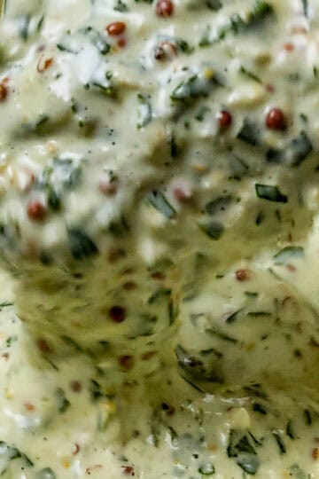 close up of the Lemon Dijon Mustard Remoulade on a spoon dripping back into a container.