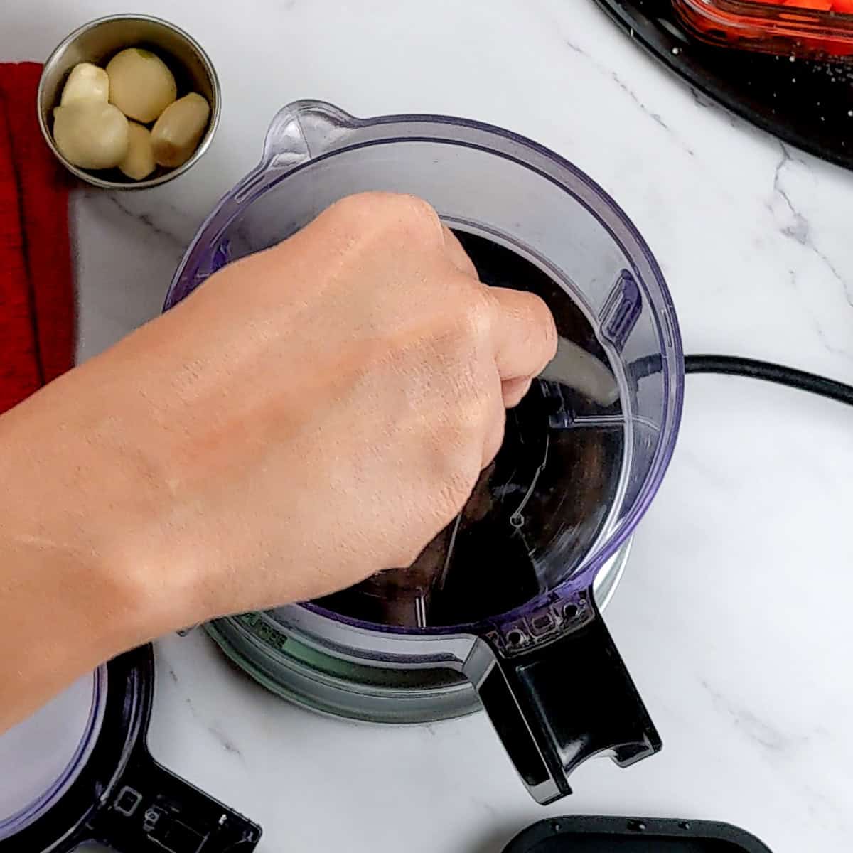 hand adjusting the kitchenaid food chopper.
