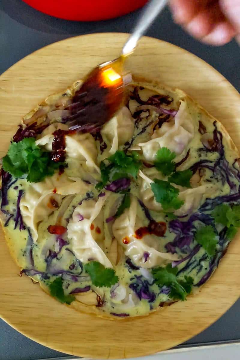 chili oil drizzled onto finished potsticker egg winged dish.