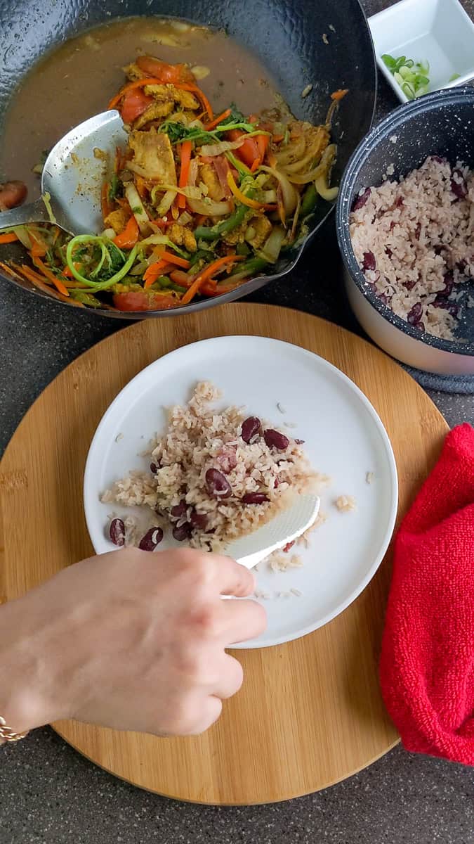 plating the coconut rice and beans that were cooked in the rice cooker.