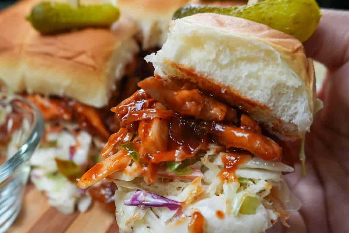 chef maika hand holding a bbq chicken slider.