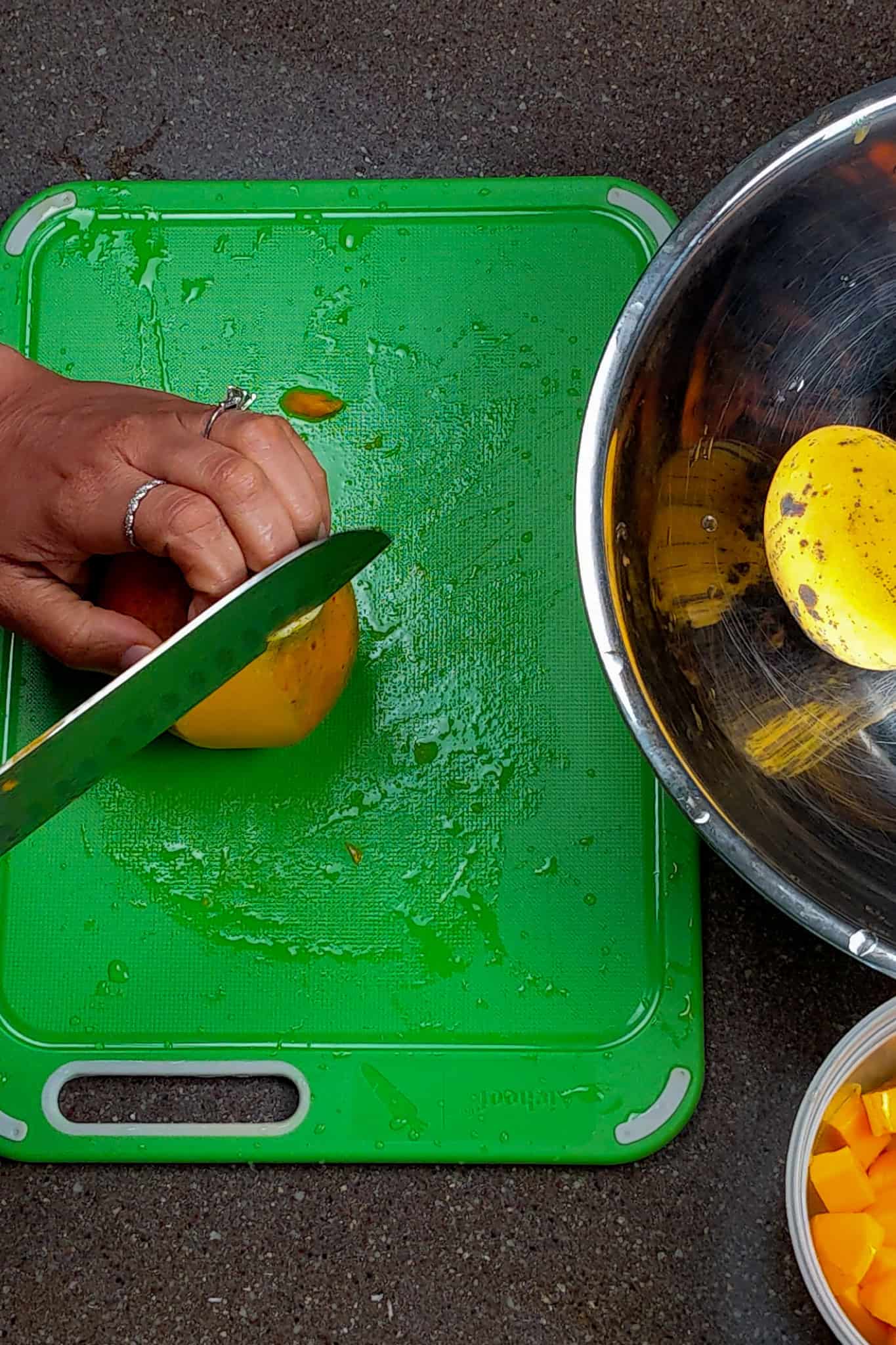 Standing the mango upright with both ends cut off for stability and the knife starting at the top to slice the skin off.